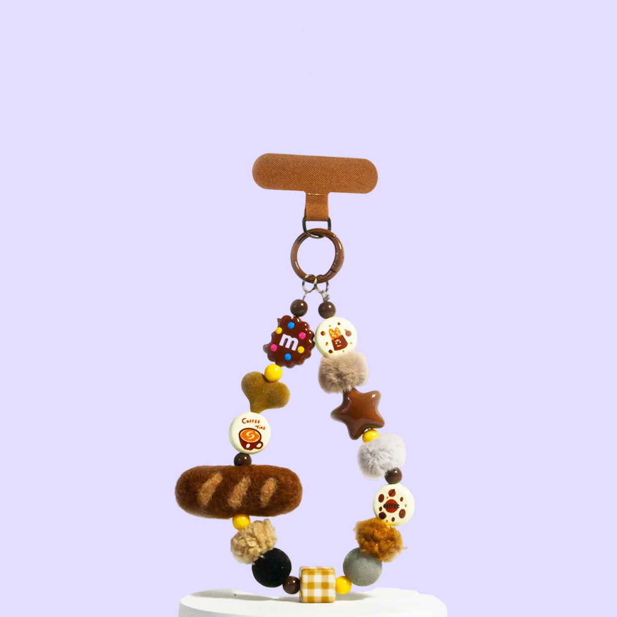 A decorative beaded keychain or bag charm. The product features a wooden T-bar hanger, a metal ring, and multiple colorful beads shaped like bread, cheese, stars, and patterns