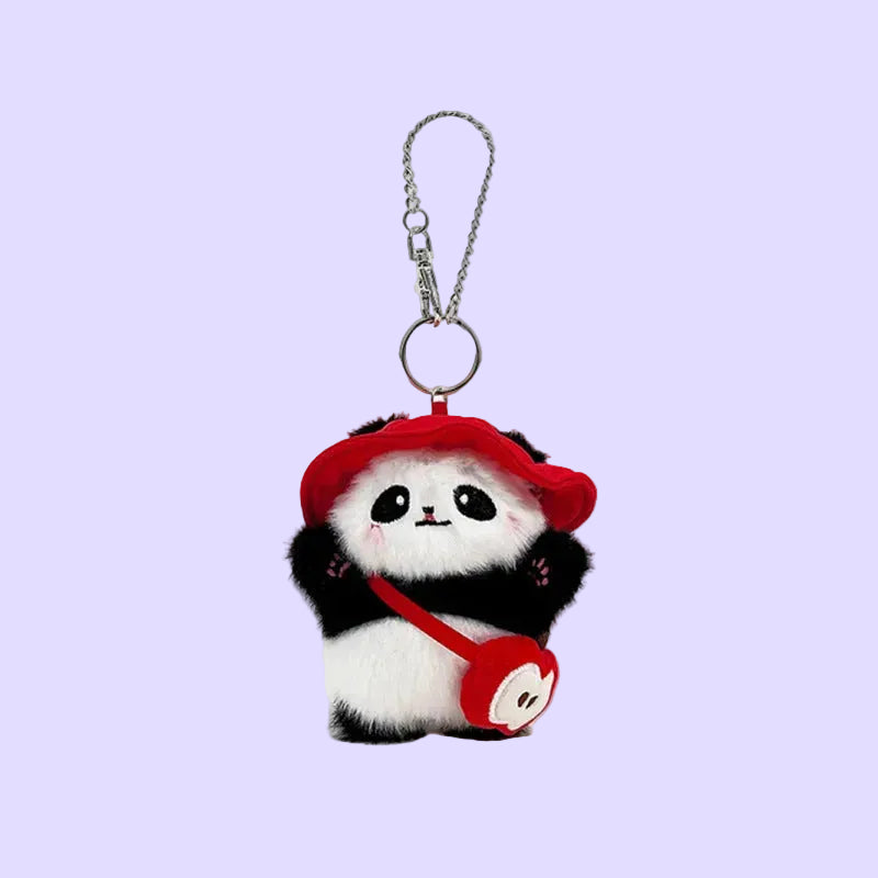 A plush panda keychain charm wearing a red beret and carrying a red crossbody bag, attached to a silver metal ring and chain.
